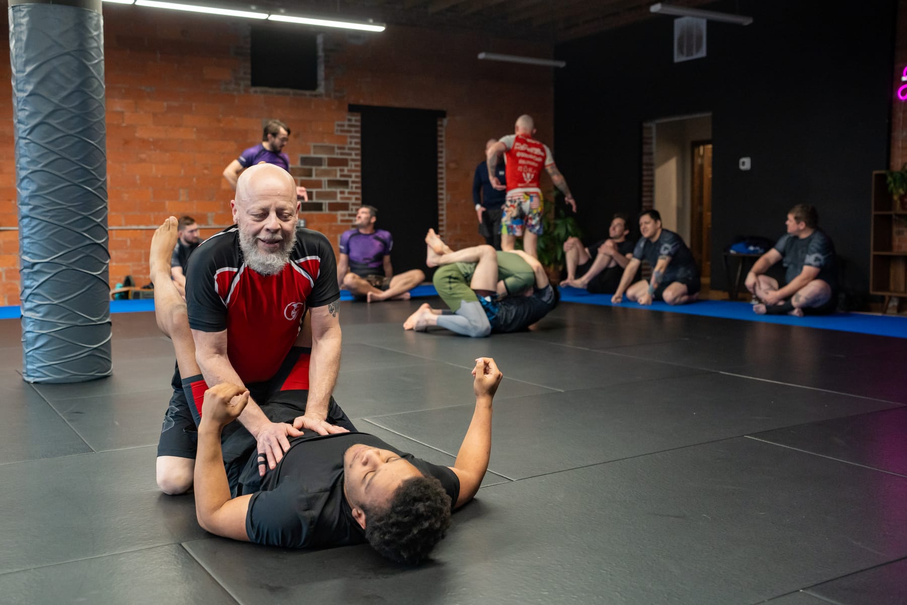 A coach working with a student on the mat at Renzo Gracie Des Moines